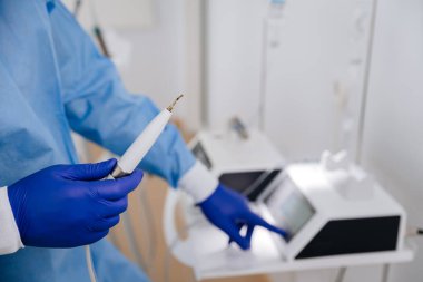 Modern bir diş kliniğinde diş temizliği için ultrasonik pulluk hazırlayan diş hekimi. Yüksek kalite fotoğraf