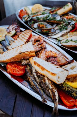 Açık hava yemekleri için taze ekmek ve sebzelerle ızgara deniz ürünleri ziyafeti. Yüksek kalite fotoğraf