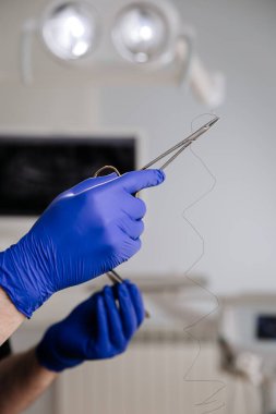 Diş ipi tutan bir diş hekimi ve klinik ortamda ağız hijyeni tanıtımı için aletler. Yüksek kalite fotoğraf