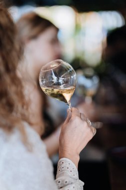 Close-up of a hand holding a wine glass at a sophisticated gathering, celebrating special moments. High quality photo clipart