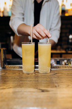 Bir barmenin hazırladığı sarı kokteyller yaz toplantıları ve kutlamalar için mükemmel. Yüksek kalite fotoğraf