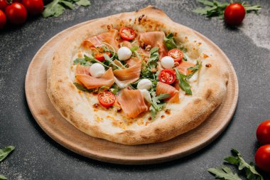 Prosciutto, mozzarella, roka ve kiraz domatesli gurme pizza. Yemek severler için mükemmel bir ziyafet. Yüksek kalite fotoğraf