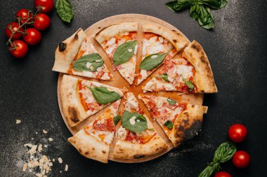 Üstü ıspanak, badem ve fesleğen yapraklarıyla kaplı kırsal ahşap tabakta zanaatkar pizza dilimleri. Yüksek kalite fotoğraf