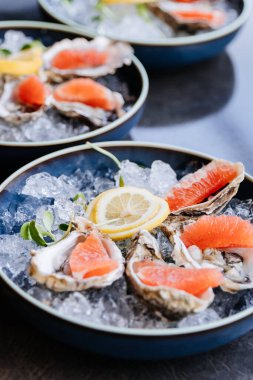 Gourmet yemek deneyimi için buzlu taze istiridye ve limonlu garnitür. Yüksek kalite fotoğraf