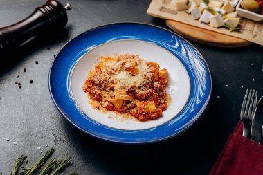Klasik mavi tabakta parmesan peynirli otantik İtalyan pappardelle bolonez. Yüksek kalite fotoğraf