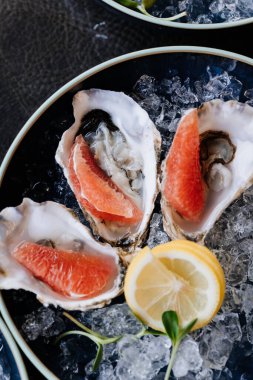 Gourmet yemek deneyimi için buzlu taze istiridye ve limonlu garnitür. Yüksek kalite fotoğraf