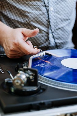 DJ spinning blue vinyl record on turntable, creating retro music vibes at an event. High quality photo clipart