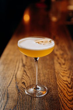 Kırsal bar tezgahında kurutulmuş elmayla süslenmiş nefis sarı kokteyl. Karışım teması için mükemmel. Yüksek kalite fotoğraf