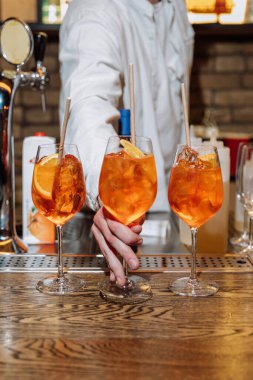 Barda servis edilen Aperol spritz kokteylleri tazeleniyor. Kutlamalar ve sosyal toplantılar için mükemmel. Yüksek kalite fotoğraf