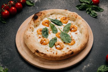 Tahta tabakta servis edilen altın hamurlu ıspanak yapraklarıyla kaplı gurme karides pizzası. Yüksek kalite fotoğraf