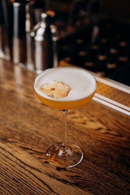 Kırsal bar tezgahında kurutulmuş elmayla süslenmiş nefis sarı kokteyl. Karışım teması için mükemmel. Yüksek kalite fotoğraf