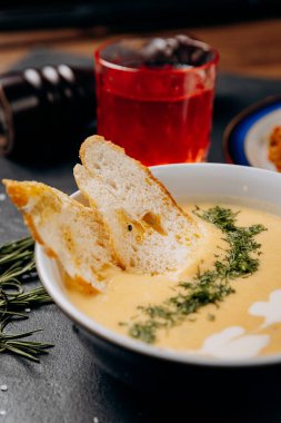 Creamy cheese soup with toasted bread slices garnished with fresh dill, perfect for a business lunch. High quality photo clipart