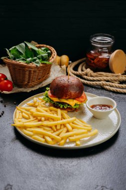 Kızarmış patates ve soslu gurme burger, şık bir restoran ortamında servis ediliyor. Yüksek kalite fotoğraf