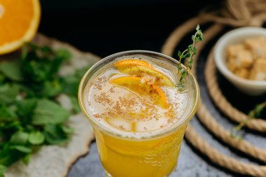 Portakal dilimleri, tarçın ve koyu arkaplandaki cam bitkilerle narenciye karışımını tazeliyorum. Yüksek kalite fotoğraf