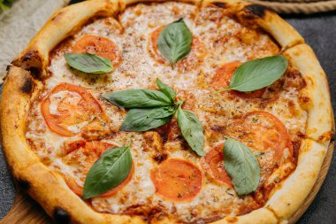 Tahta tahtada taze fesleğen, domates ve mozzarella ile klasik Margherita pizzası. Yüksek kalite fotoğraf