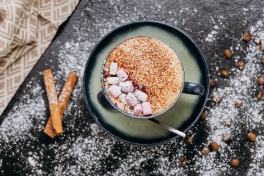 Bir fincan kremalı sıcak çikolata ve kırsal arka planda kakao tozu. Yüksek kalite fotoğraf