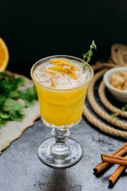 Portakal dilimleri, tarçın ve koyu arkaplandaki cam bitkilerle narenciye karışımını tazeliyorum. Yüksek kalite fotoğraf