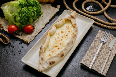 Zarif ve geleneksel yemek sunumunda eritilmiş mozzarella ile Türk peyniri pidesi. Yüksek kalite fotoğraf