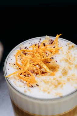 Çırpılmış köpüklü, portakal aromalı ve baharatlı gurme latte, kırsal ve karanlık bir yüzeyde servis edilir. Yüksek kalite fotoğraf