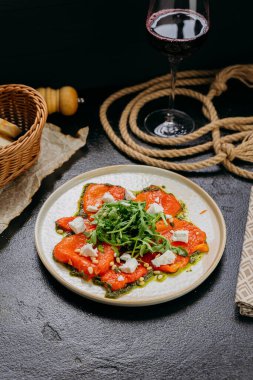 Kavrulmuş dolmalık biberli carpaccio roka, peynir, çam fıstığı ve pesto, gurme usulü. Yüksek kalite fotoğraf