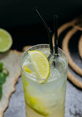 Ezilmiş buz, taze nane ve uzun bardakta siyah pipetle ferahlatıcı limon kokteyli. Yüksek kalite fotoğraf