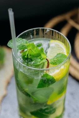 Yaz içeceği için uzun bir bardakta servis edilen limon, nane ve buzlu mojito kokteyli. Yüksek kalite fotoğraf