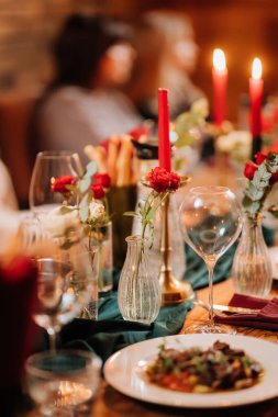 Şık bir masa dekoruyla mum ışığında romantik bir akşam yemeğinde bir bardağa gül şarabı dökmek. Yüksek kalite fotoğraf