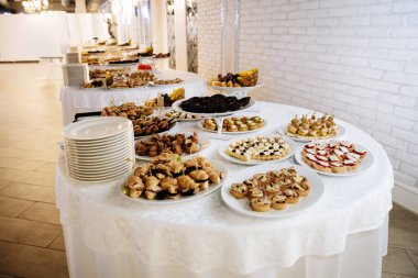 Şenlik şöleninde gurme kanepeler, tatlılar ve meyvelerle nefis bir açık büfe masası. Yüksek kalite fotoğraf