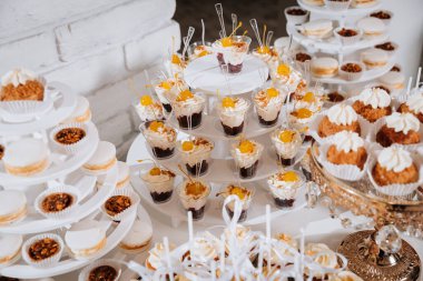 Lüks kekler, kurabiyeler, kurabiyeler ve zarif altın tepsilerde tatlılar. Yüksek kalite fotoğraf