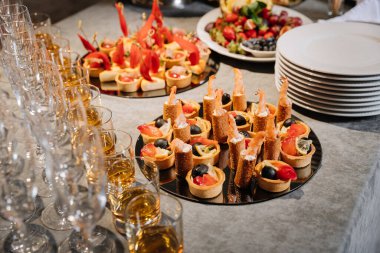 Şık yemek masasında gurme aperatifler, viski kadehleri ve şampanya bardakları. Yüksek kalite fotoğraf