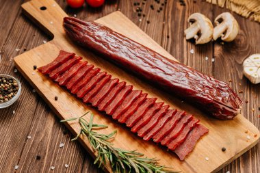 Dilimlenmiş sosis, ahşap tahta, baharat ve kırsal gıda tasarımı. Yüksek kalite fotoğraf