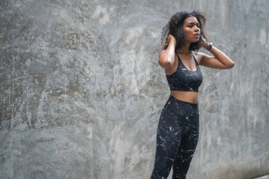 Güçlü bir atletik. Bayan sprinter. Spor kıyafetlerini giymiş Afrikalı kadınlar şehirde dikiliyor. Fotokopi alanı ile spor motivasyonu kavramı. Kameraya bakan gülümseyen siyah kadınlar..