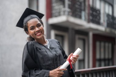 Siyahi mezuniyet elbiseli Afrikalı öğrenciler diplomayı tutuyor ve birlikte duruyorlar. Mutluluk ve zarafetle.