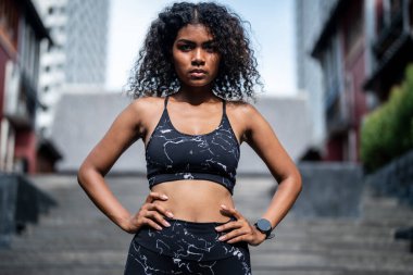 Güçlü bir atletik. Bayan sprinter. Spor kıyafetlerini giymiş Afrikalı kadınlar şehirde dikiliyor. Fotokopi alanı ile spor motivasyonu kavramı. Kameraya bakan gülümseyen siyah kadınlar..