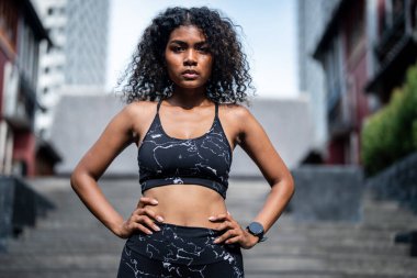 Güçlü bir atletik. Bayan sprinter. Spor kıyafetlerini giymiş Afrikalı kadınlar şehirde dikiliyor. Fotokopi alanı ile spor motivasyonu kavramı. Kameraya bakan gülümseyen siyah kadınlar..