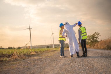 Asyalı mühendis. Ve Arap işadamı gün batımında gökyüzü ile inşaat ve teftiş yaptıktan sonra el sıkışıyor. İnsanlar uluslararası iş sektörünü yönetiyor.