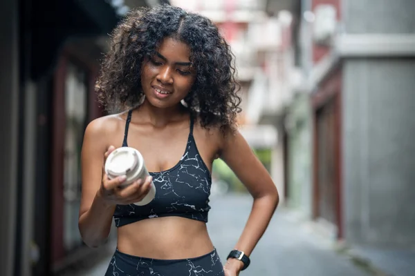 African woman sport healthy fit and firm slim drink water from cup on the hand. athletic running wearing in the sportswear at city and town. Fitness and sport motivation. Runner concept.
