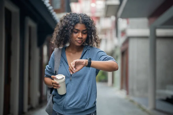 African woman sport healthy fit and firm slim drink water from cup on the hand. fitness girl wearing sportswear and jacket walking at city and town. Fitness and sport motivation.
