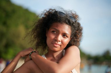 Kadınlar dışarıda egzersiz yapmadan önce kaslarını çalıştırır ve gerer. Seksi Asyalı Afrikalı kadın plajda spor yapmaya hazırlanıyor..