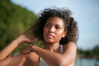 Kadınlar dışarıda egzersiz yapmadan önce kaslarını çalıştırır ve gerer. Seksi Asyalı Afrikalı kadın plajda spor yapmaya hazırlanıyor..