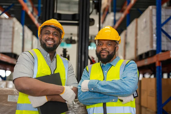非洲男工穿着工作服 头戴安全帽 在工厂仓库工作 检查质量控制 — 图库照片