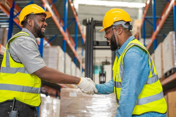 非洲工程师和技术人员在检查货物是否有堆栈项目供运输 工业厂房仓库后握手 — 图库照片