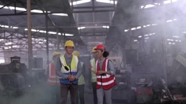 Çeşitli fabrika çalışanlarından oluşan bir grup yerel depoyu teftiş ediyor ve kontrol ediyor. Asyalı, beyaz, beyaz ve Asyalı insanlar ağır makine fabrikasında. Konsept Mühendisi İşletim ve Kontrol.
