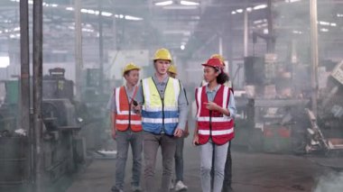 Çeşitli fabrika çalışanlarından oluşan bir grup yerel depoyu teftiş ediyor ve kontrol ediyor. Asyalı, beyaz, beyaz ve Asyalı insanlar ağır makine fabrikasında. Konsept Mühendisi İşletim ve Kontrol.