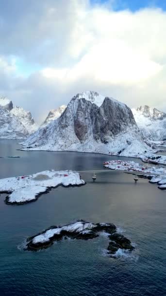 ロフテン島ノルウェーの空中ビュー 雪景色の山のピークとラインの日の出漁村の冬の季節は水に反映されます ノルウェーでは赤の家がある 冬に雪が降ると — ストック動画