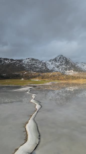 雪の山の頂上と美しい白い冬の不思議の国の風景のパノラマビューは 空と雲と冷たい晴れた日に透明な氷の湖に反映されます ノルウェーのフィヨルド山 — ストック動画