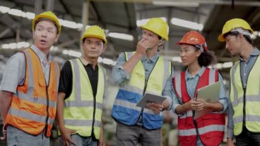 Bir grup çeşitlilik fabrikası çalışanı proje başarıya ulaştığında ayakta duruyor ve yerel depoda birlikte kutluyorlar, Asyalı, beyaz, beyaz ve Asyalı insanlar ağır makine fabrikasında çalışıyorlar..