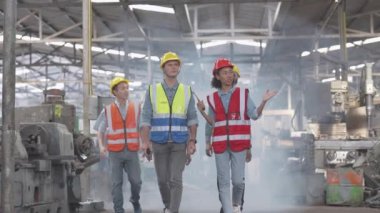 Bir grup çeşitlilik fabrikası çalışanı proje başarıya ulaştığında ayakta duruyor ve yerel depoda birlikte kutluyorlar, Asyalı, beyaz, beyaz ve Asyalı insanlar ağır makine fabrikasında çalışıyorlar..