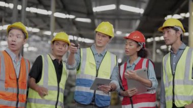 Bir grup çeşitlilik fabrikası çalışanı proje başarıya ulaştığında ayakta duruyor ve yerel depoda birlikte kutluyorlar, Asyalı, beyaz, beyaz ve Asyalı insanlar ağır makine fabrikasında çalışıyorlar..