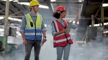 Bir grup çeşitlilik fabrikası çalışanı proje başarıya ulaştığında ayakta duruyor ve yerel depoda birlikte kutluyorlar, Asyalı, beyaz, beyaz ve Asyalı insanlar ağır makine fabrikasında çalışıyorlar..